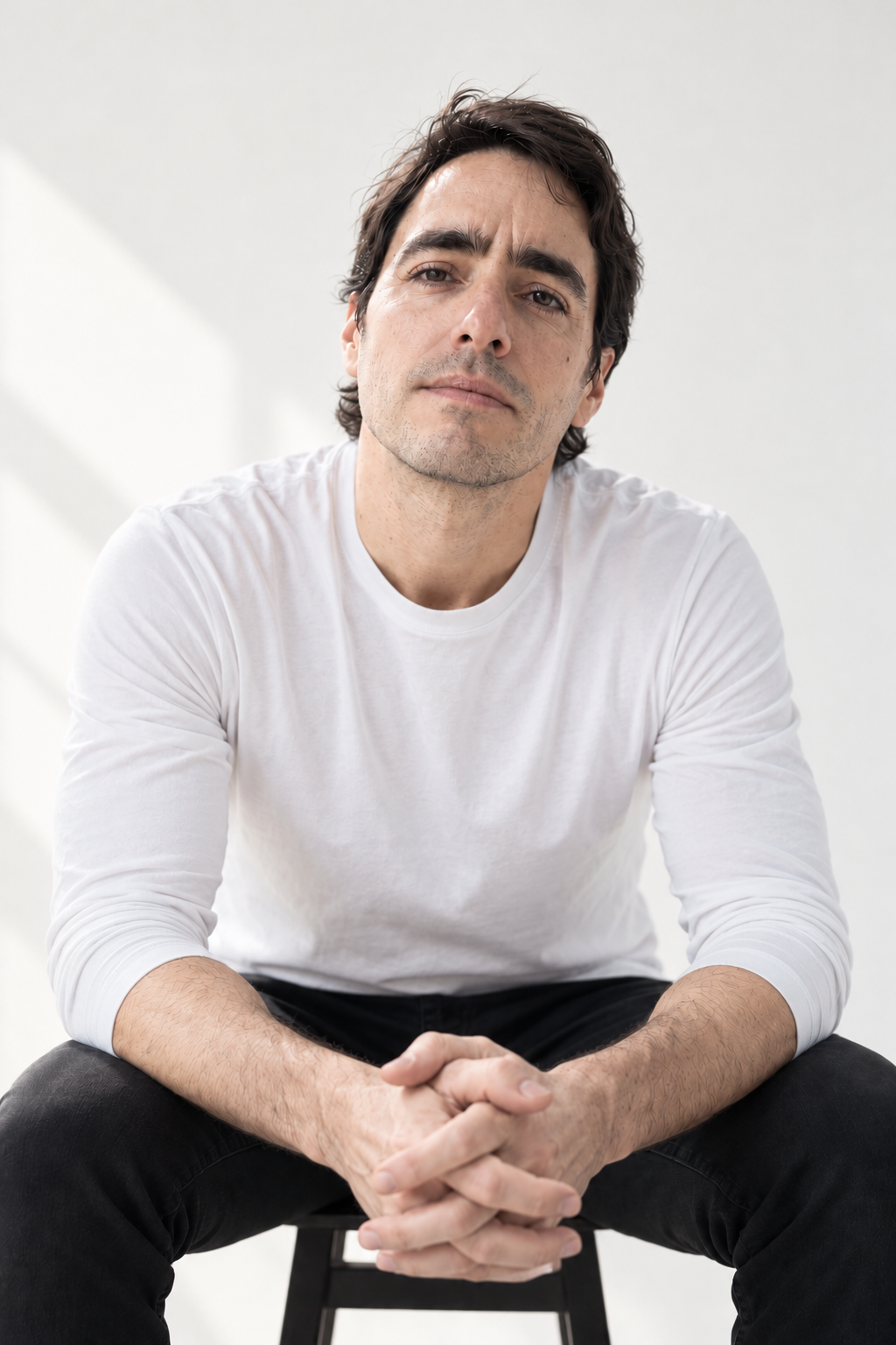 Retrato de Sergio Gimenez sentado frente a un fondo claro